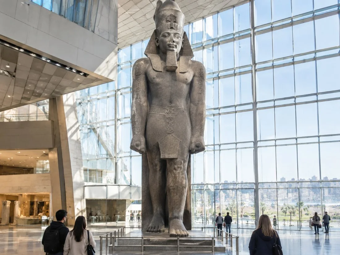 ’n Kolossale staande standbeeld van Ramesses II in die helder atrium van die Groot Egiptiese Museum
